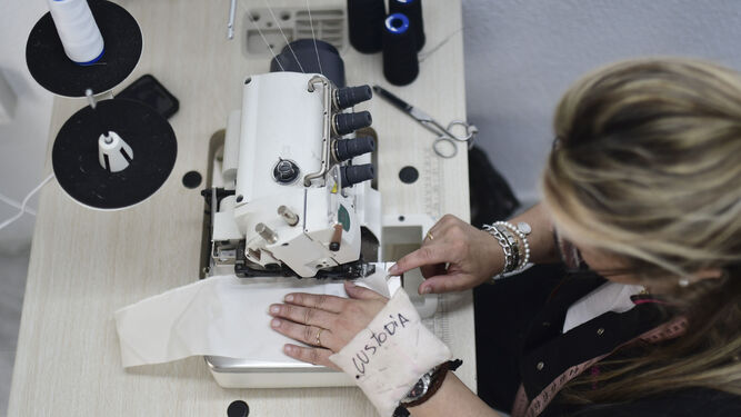 Una mujer, en un taller de costura de Cáritas.