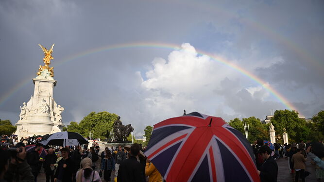 Un arcoiris aparece sobre el Queen Victoria Memorial mientras la gente se reúne frente al Palacio de Buckingham este jueves.