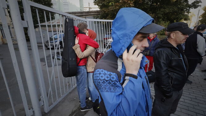 Ciudadanos rusos se despiden de sus familias ante un centro de reclutamiento en San Petersburgo.
