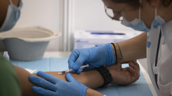 Una sanitaria inocula una vacuna de la viruela del mono a un paciente.