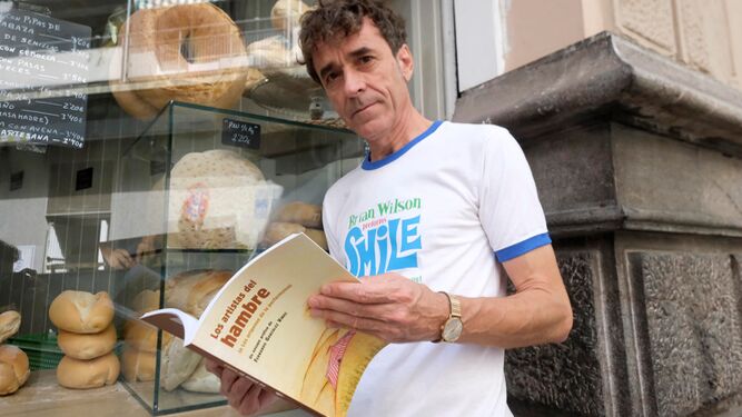 González Viñas, con su libro 'Los artistas del hambre', en la puerta de una panadería.