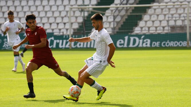 Marc Esteban controla el balón ante la presión de un futbolista del Sevilla C.