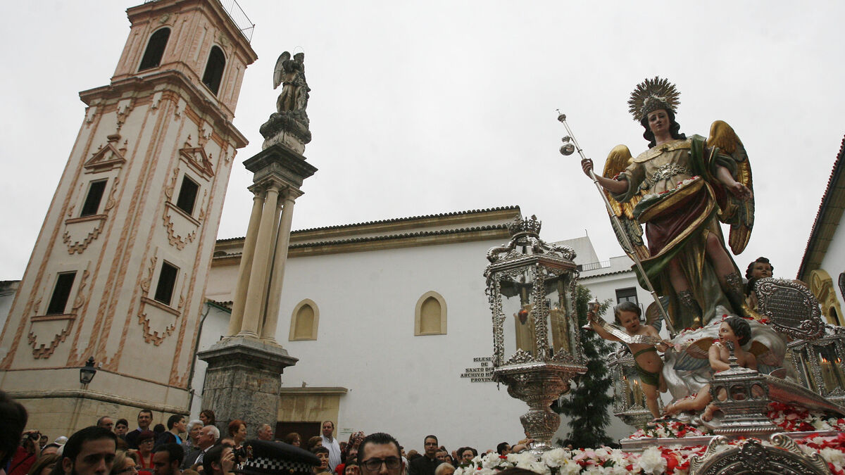 La imagen de la San Rafael pasa en procesión junto a uno de los triunfos que le ha dedicado la ciudad.