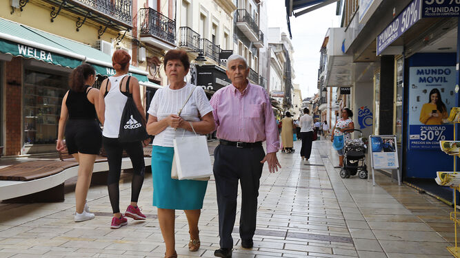 Dos pensionistas transitan por el centro de Huelva.