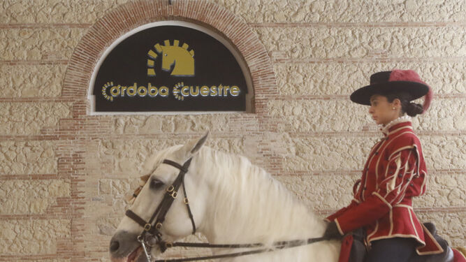 Una amazona pasa junto al logo de Córdoba Ecuestre.