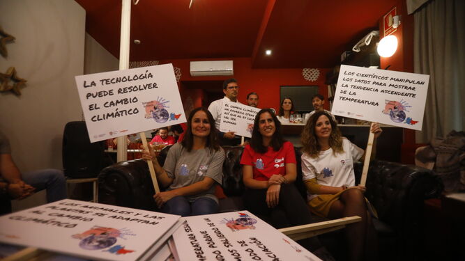 Investigadoras de la UCO sostienen varias pancartas con bulos contra el cambio climático.