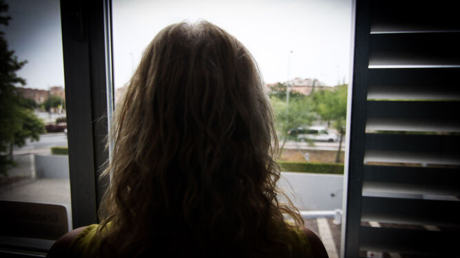 Una mujer mira por una ventana.