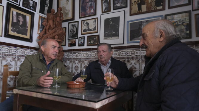Tres hombres toman vino en la Taberna La Fuenseca.