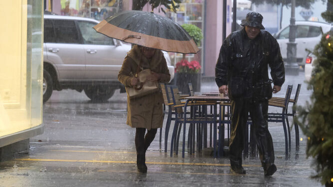 Dos personas se protegen de la intensa lluvia caída en Córdoba.