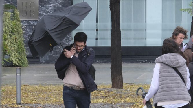 Un hombre se resguarda bajo un paraguas.