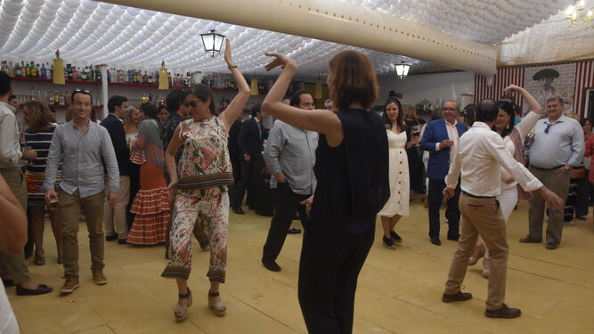 Unas mujeres bailan en una de las casetas de la Feria de Córdoba.