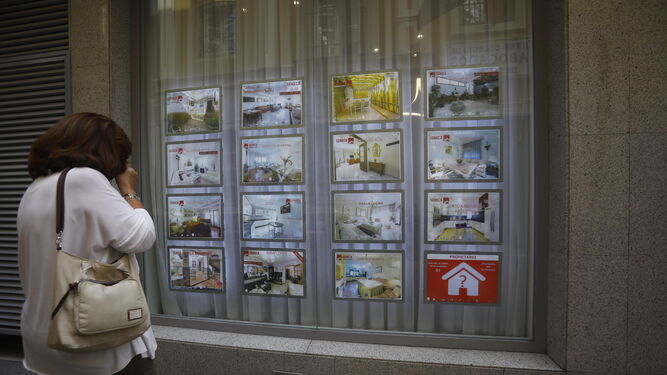 Una mujer mira los anuncios de una inmobiliaria.