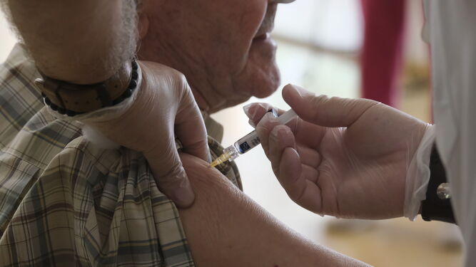Un enfermero vacuna contra la gripe a un paciente.