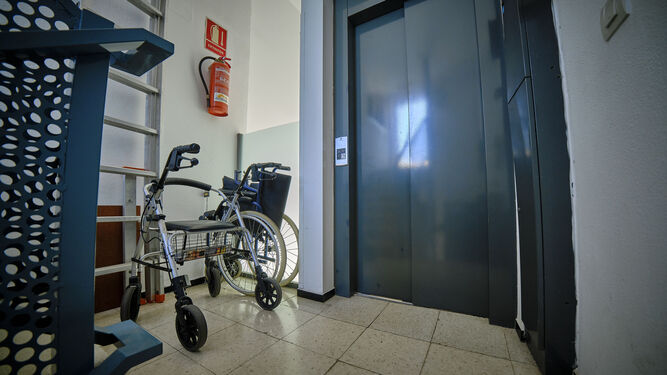 Un andador y una silla de ruedas, junto a un ascensor.