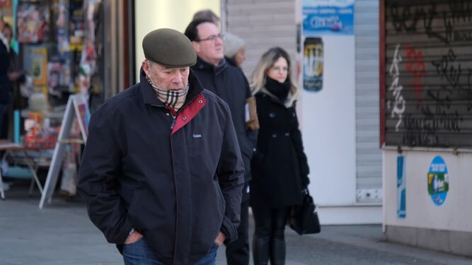 Varias personas caminan por una calle de Córdoba en un día frío.