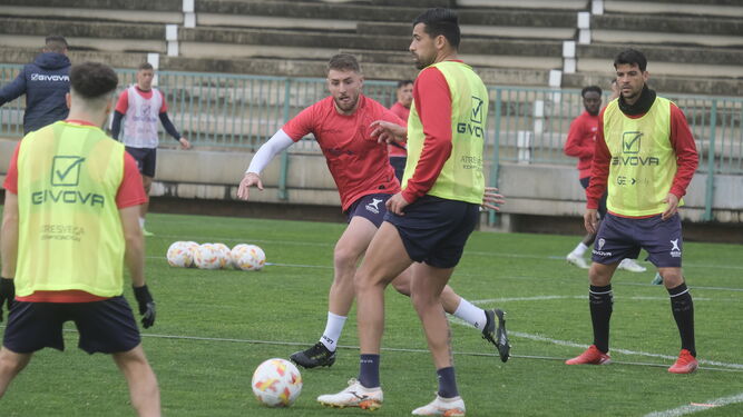 Alberto Jiménez pasa un balón ante la mirada de Casas y José Ruiz durante un entrenamiento.