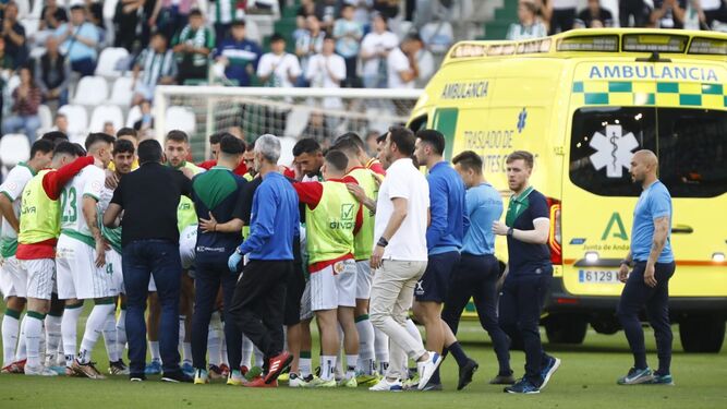 Los jugadores del Córdoba CF se reúnen en el centro del campo mientras Gudelj abandona el estadio en ambulancia.