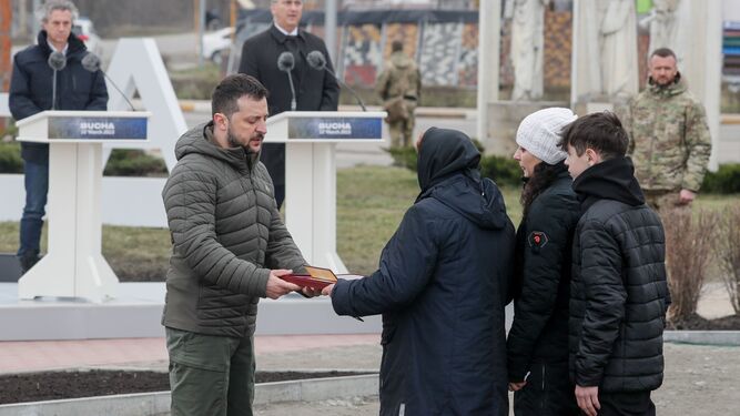 El presidente ucraniano, Volodimir Zelenski, entrega la orden a la familia de un soldado caído tras una ceremonia cerca de Bucha.