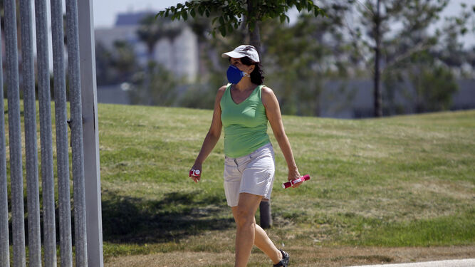 Una mujer practica deporte en un parque de la ciudad con una mascarilla especial destinada a reducir los efectos de la alergia.