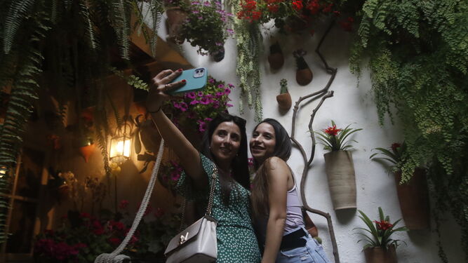 Dos jóvenes se hacen una fotografía en un Patio de Córdoba.