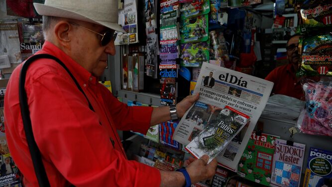 Una persona compra el Día de Córdoba con la Guía de Patios.