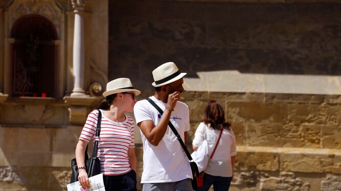 Dos personas pasean por el entorno de la Mezquita-Catedral de Córdoba.