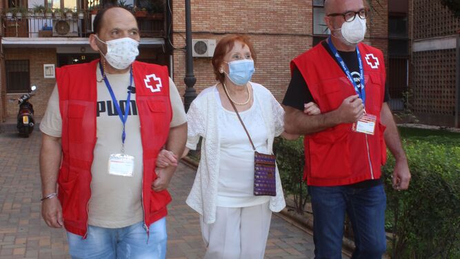 Voluntarios de Cruz Roja acompañan a una mujer a votar en las últimas elecciones en Córdoba.