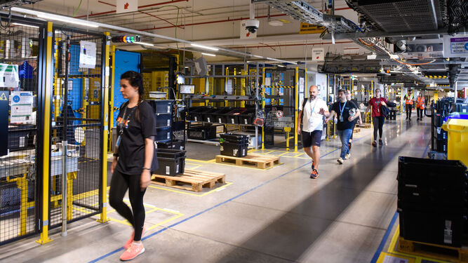 Trabajadores de Amazon cambian de turno en la zona robotizada de su principal centro logístico en Sevilla.