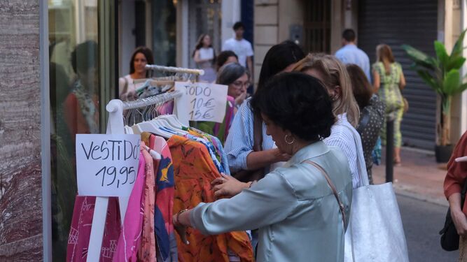 Unas mujeres comprueban unos vestidos en la Shopping Night 2023.