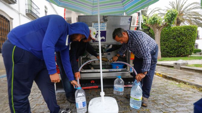 Varios vecinos del norte de Córdoba recogen agua de un camión cisterna.