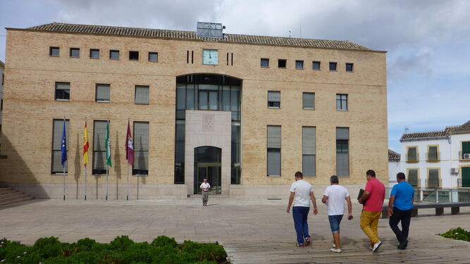 Varias personas acceden al Ayuntamiento de Baena.