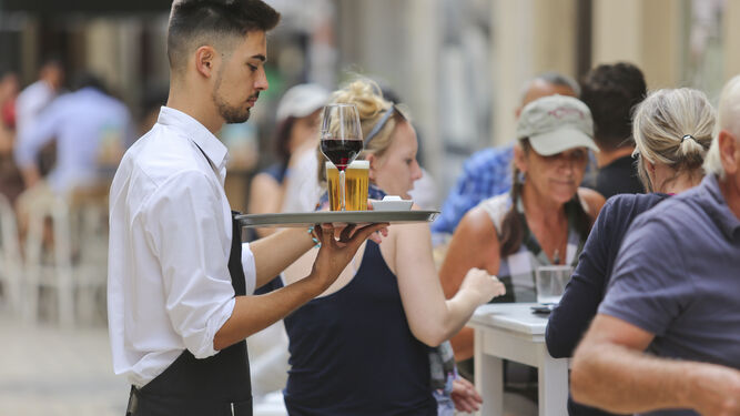 Un camarero atiende a unos clientes.