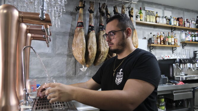 Un camarero sirve un vaso de agua en un bar de Lucena.