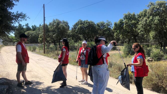 Voluntarios de Cruz Roja limpian una zona verde.
