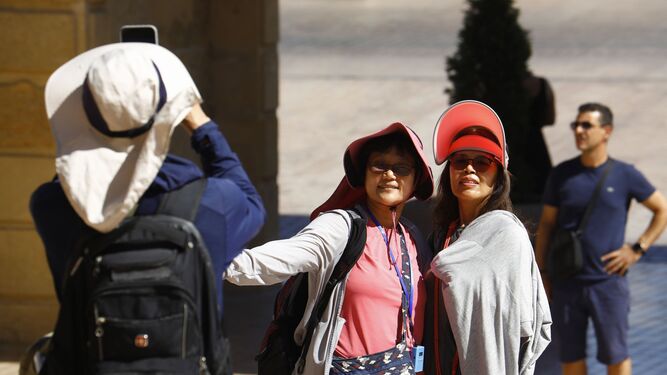 Dos turistas se toman una foto en la zona de la Puerta del Puente de Córdoba.