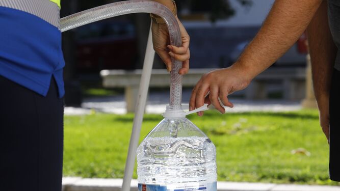 Un vecino llena una botella de agua de un camión cisterna.
