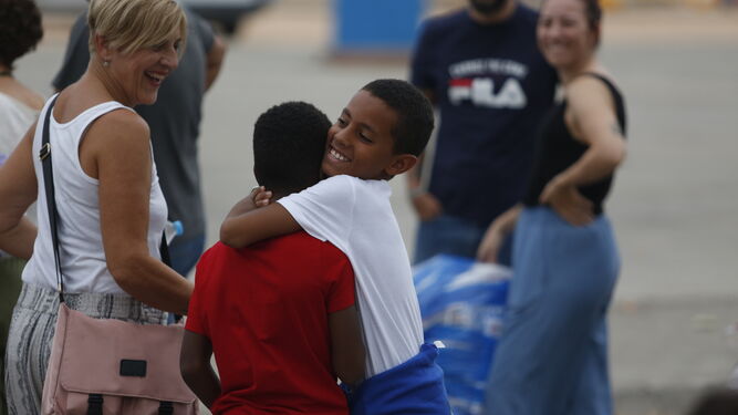 Unos niños se dan un abrazo en El Arenal.