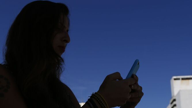 Una mujer mira su teléfono móvil, en una imagen de archivo.