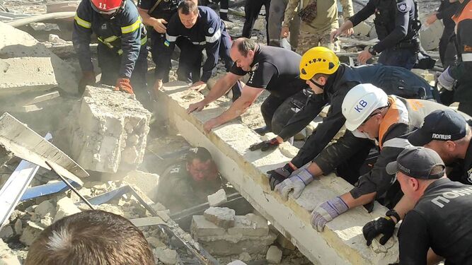 Equipos de rescate tratan de liberar a un agente atrapado entre los escombros tras el ataque ruso en Krivi Rig.