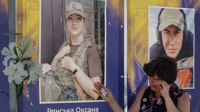 Una mujer llora ante la imagen de una militar fallecida defendiendo Mariupol en una plaza de Kiev.