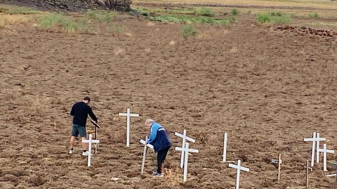 Dos personas ponen unas cruces en Sierra Boyera tras la marcha del domingo desde Peñarroya.