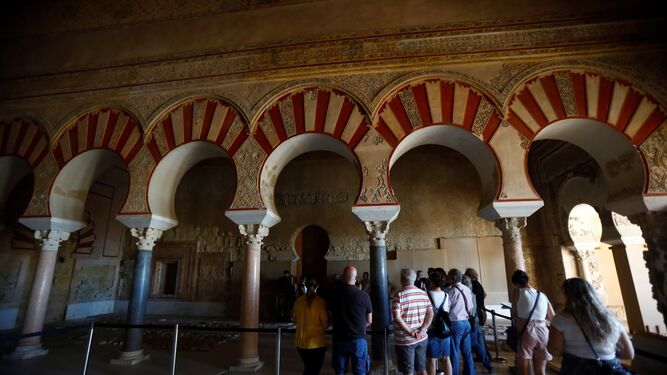 Varias personas observan algunos de los elementos del Salón Rico de Medina Azahara.