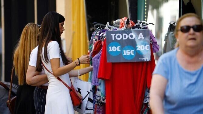 Varias personas observan ropa en una tienda de Córdoba.