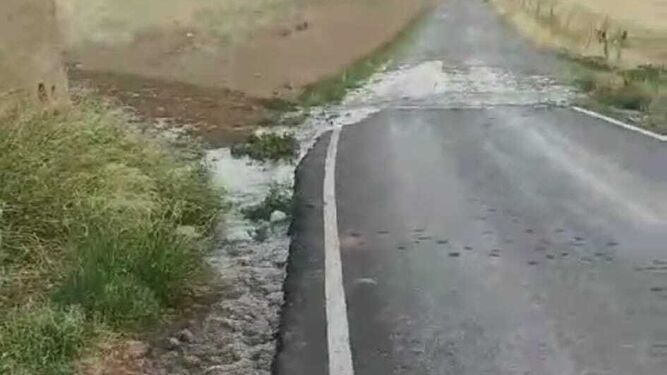 Imagen del agua salvando una carretera por la avería que sufren los depósitos.