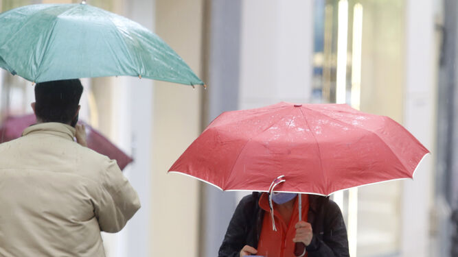 Varias personas se protegen de la lluvia en Córdoba.