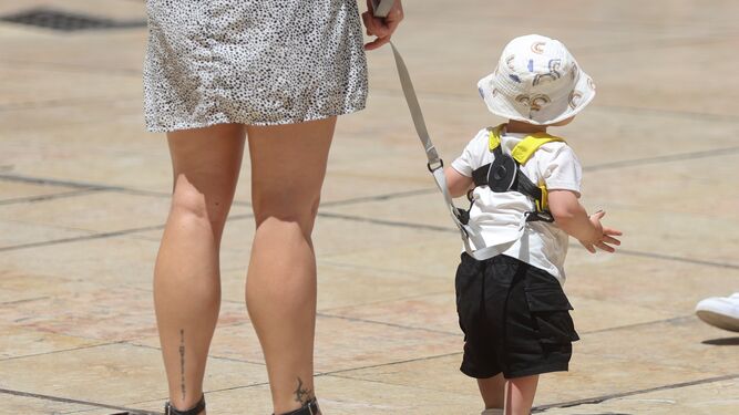 Una madre sujeta a su hijo mientras camina.