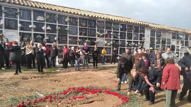 Familiares de represaliados depositan flores sobre una de las fosas de La Salud.