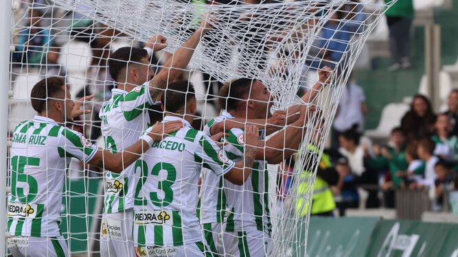 Kike Márquez, capitán del Córdoba CF, celebra con rabia su gol al Ceuta mientras es abrazado por sus compañeros.
