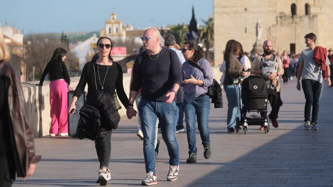 Personas caminando por el Puente Romano de Córdoba.