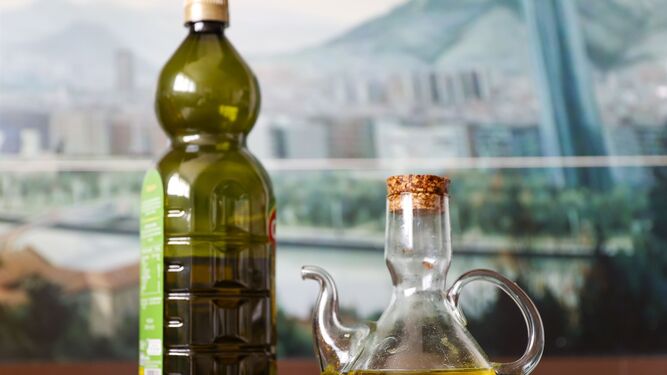 Una botella y una aceitera con aceite  de oliva  virgen.